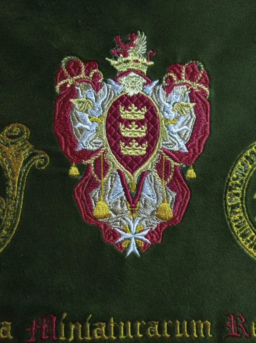 Close-up of the studio arms, hand-embroidered in silk on green velvet